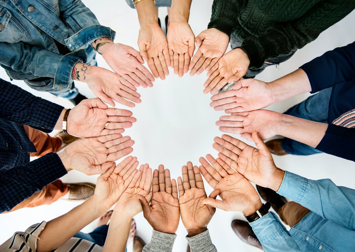Hands gathered in a circle representing peer support